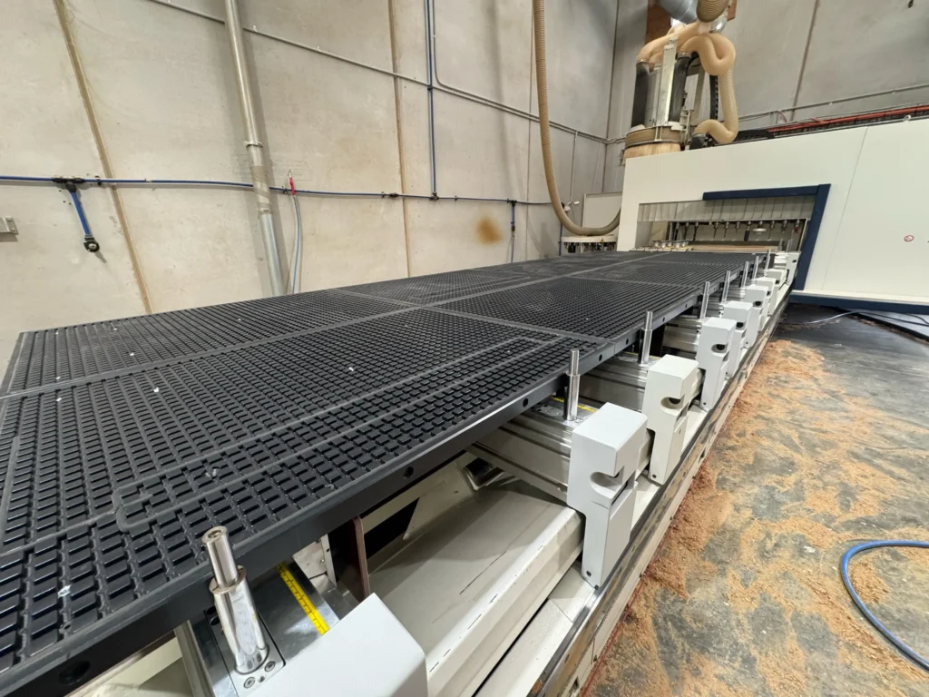 Módulo nesting Vacuum CNC instalado en máquina de consolas, convirtiendo un sistema pod and rail en mesa nesting para paneles